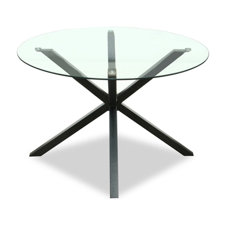 Vestamby round glass dining table by Hill Interiors with clear tempered top and black crossed metal base, shown on a plain white background.