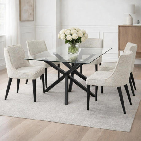 Hill Interiors Vestamby rectangular glass dining table with black crossed base, styled with cream upholstered chairs and white roses in a bright dining room.