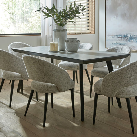 Hill Interiors rectangular dining table in matte black metal, styled in a dining room with boucle chairs, ceramic vases and foliage.