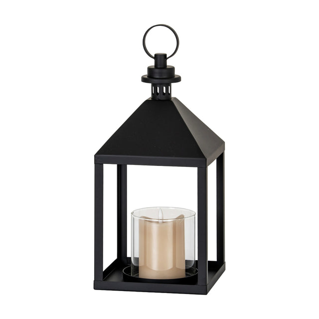 Hill Interiors medium black metal lantern candle holder with clear glass panel, pitched roof and ring handle, holding a pillar candle on a white background.