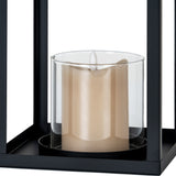 Close-up of Hill Interiors Medium Glass Lantern Candle Holder in black, showing the clear glass hurricane and cream pillar candle within the metal frame.