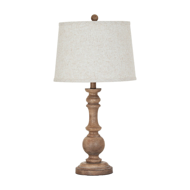 Hill Interiors Velantha table lamp with a sculptural brown resin candlestick base and tapered edged linen shade, shown on a plain white background.