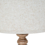 Close-up of the Hill Interiors Velantha table lamp showing the edged linen shade trim and turned brown resin base detail.