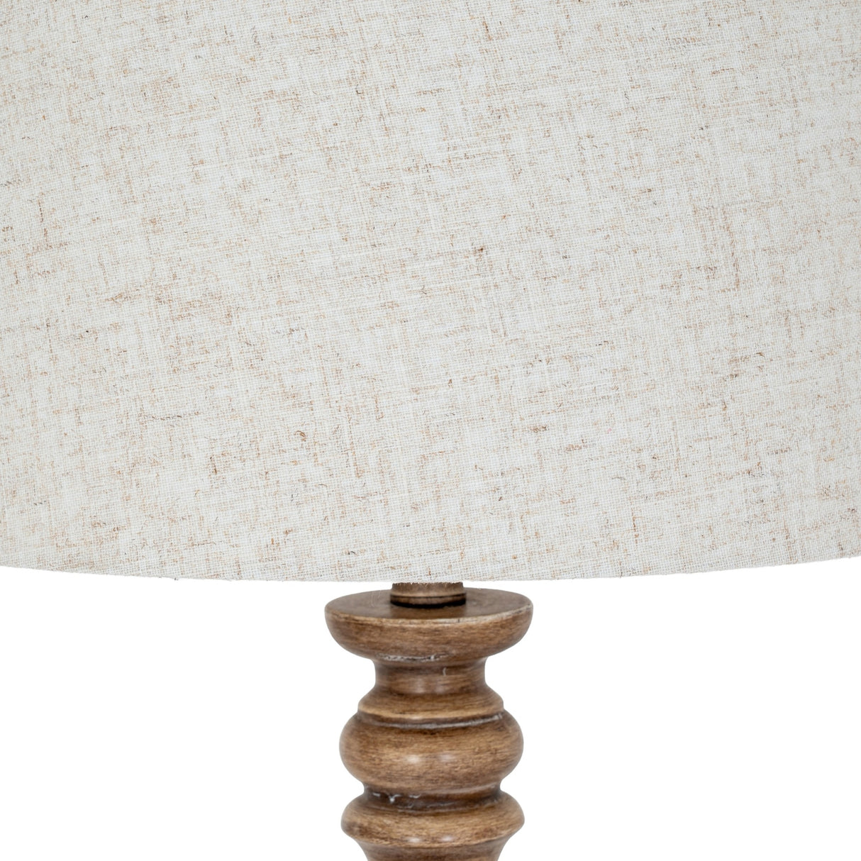 Close-up of the Hill Interiors Velantha floor lamp showing its turned brown resin base and edged natural linen drum shade against a white background.
