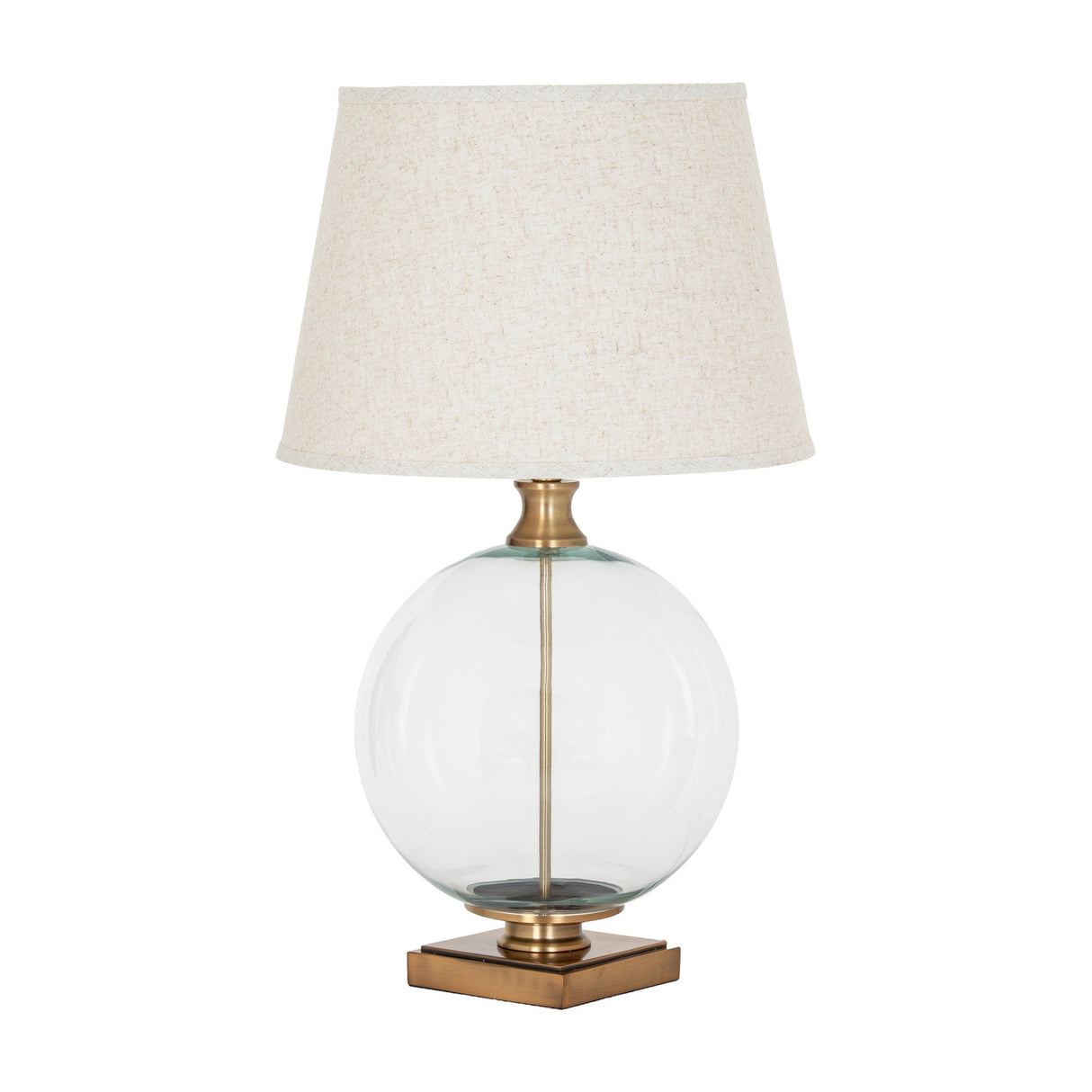 Hill Interiors Glass Orb Table Lamp with clear round base, brass-finished detailing and tapered natural linen shade with edged trim on white.
