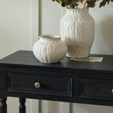 Hill Interiors Squat Ceramic Vase in white with a rounded textured body, shown on a black console table beside a taller matching vase holding stems.