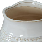 Close-up of the Hill Interiors Hewn Bud Vase in white, showing its wavy rim, glossy ceramic glaze and carved textured band on a plain background.