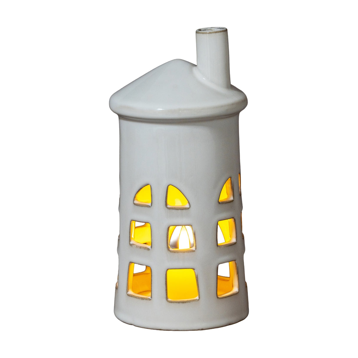 Hill Interiors Medium Lighthouse ceramic tealight holder in white with tapered tower, chimney top and cut-out windows glowing from a lit tealight inside.