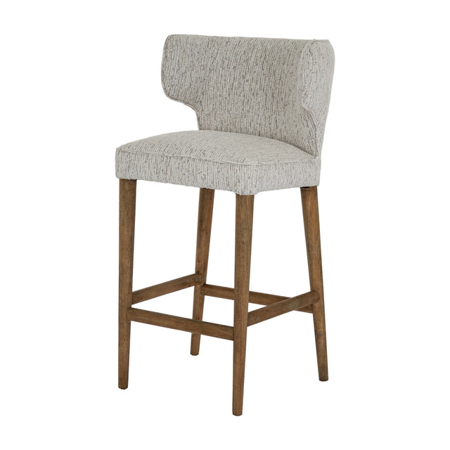 Hill Interiors Quennomer bar stool with grey textured upholstered wingback seat and solid wood legs with footrest, on a plain white background.