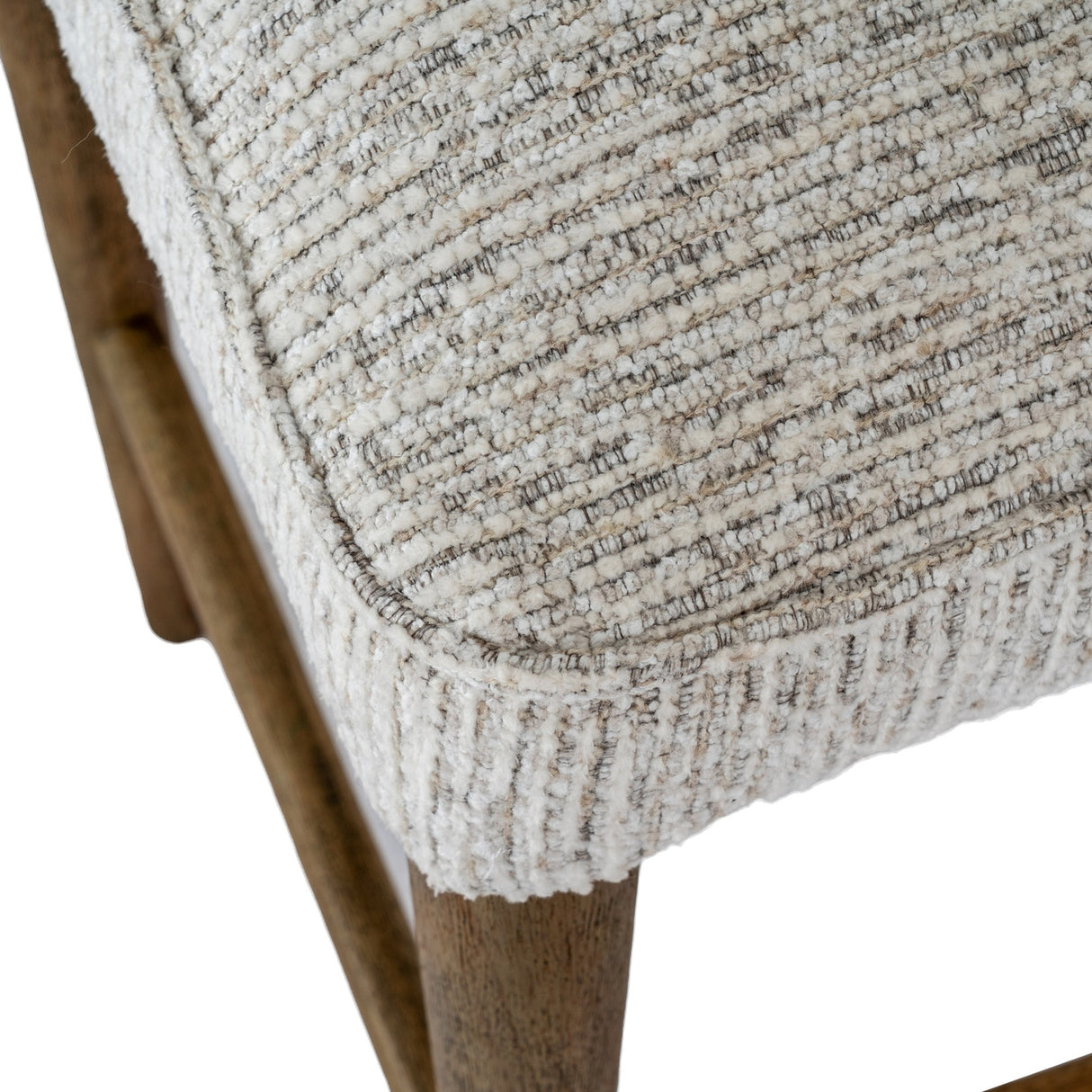 Close-up of Hill Interiors Quennomer bar stool showing textured grey woven upholstered seat with piped edge and solid wood leg in a soft grey finish.