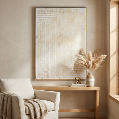Hill Interiors hand painted canvas wall art in a wooden frame, featuring cream and beige linear brushstrokes, hung above a console table in a living room.