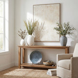 Hill Interiors hand painted canvas wall art in a wooden frame with a multicoloured cream and beige composition, above a wooden console styled with vases.