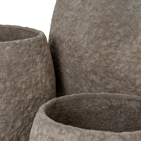 Close-up of Hill Interiors Pot Belly concrete planters showing the mottled brown textured surface and rounded rims of the grouped trio.