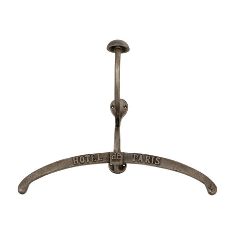 Hill Interiors silver metal coat hanger with curved arms embossed Hotel de Paris, topped by a hook and domed knob, shown on a plain white background.