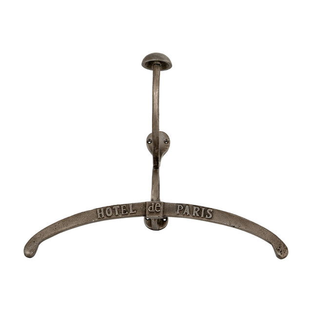Hill Interiors silver metal coat hanger with curved arms embossed Hotel de Paris, topped by a hook and domed knob, shown on a plain white background.