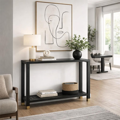Hill Interiors Harweld black console table with slim frame and lower shelf, styled with a lamp, vase and books in a bright modern hallway.