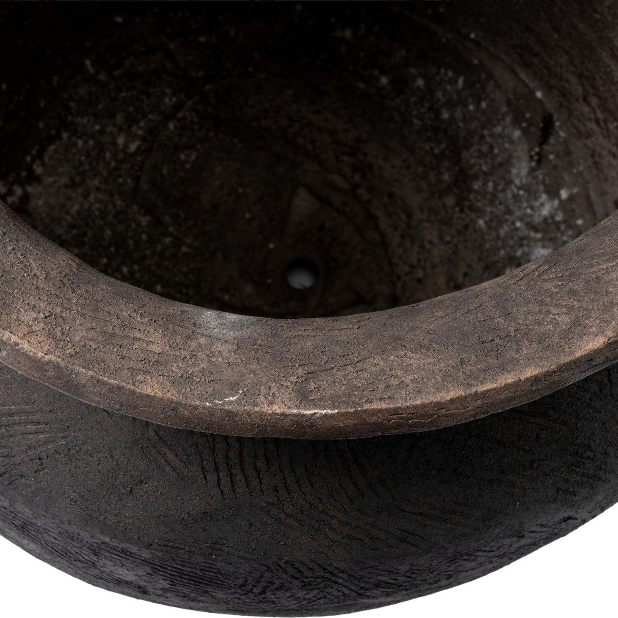 Close-up of the Hill Interiors Earthen Wash Concrete Planter showing the rolled rim, washed brown tones, and textured interior with a small drainage hole.