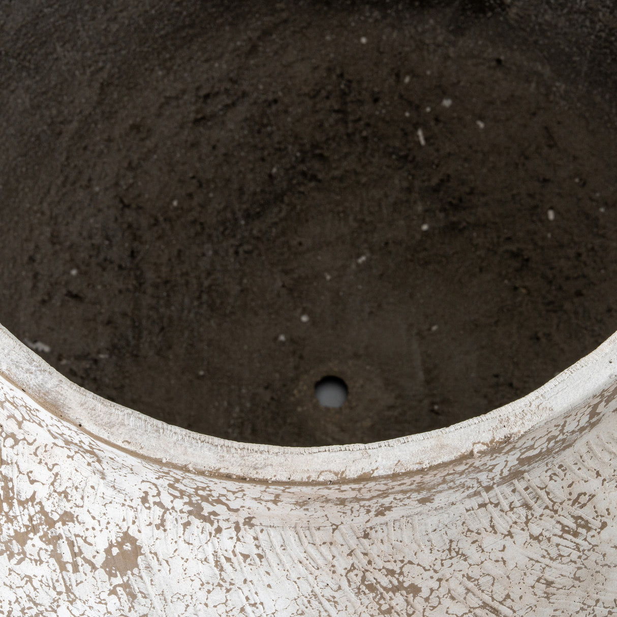 Close-up of Hill Interiors Rustic Wash Concrete Planter showing the weathered white-washed rim and textured dark grey interior with a drainage hole.