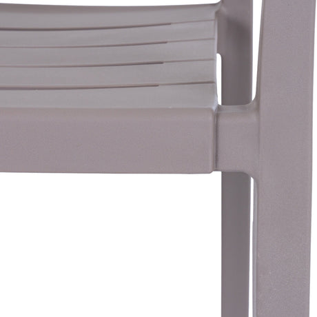 Close-up of the Hill Interiors Stone Carver Accent Chair in beige, showing the moulded seat edge, slatted detail and slender leg in a matte stone finish.