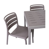 Hill Interiors Stone-Effect Side Table in beige, shown with two slatted chairs against a plain white background.