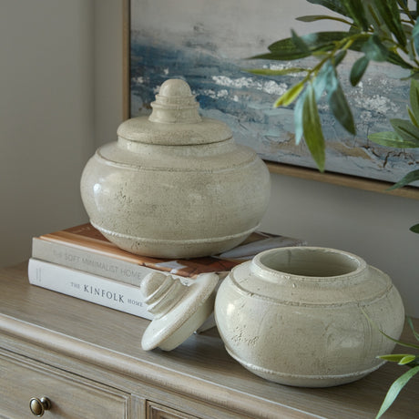 Hill Interiors medium white ceramic pots styled on a sideboard with books, one lidded and one open with lid resting beside it.