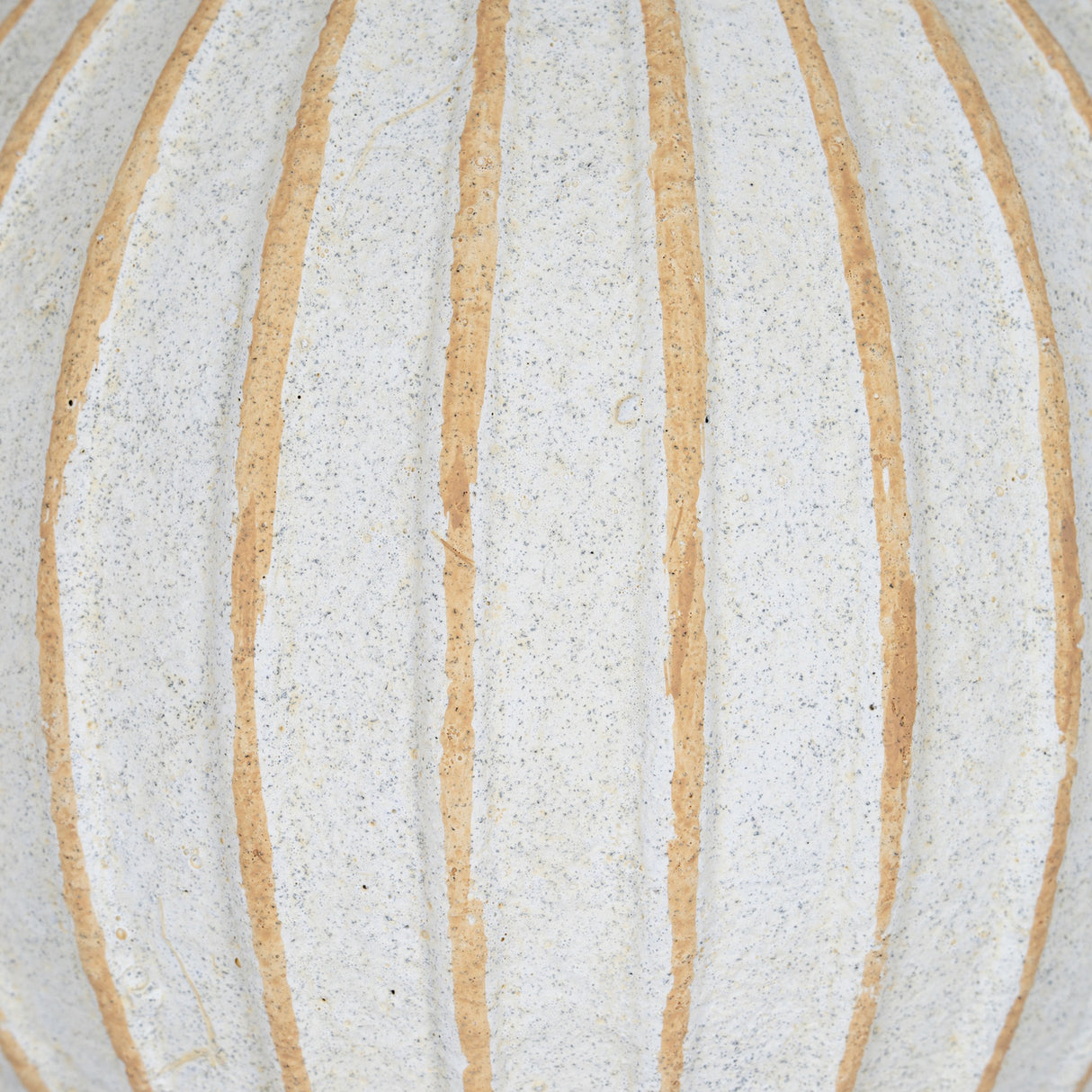 Close-up of the Hill Interiors Medium Decorative Ceramic Ball in white, showing the speckled glaze and raised tan vertical ribs across its rounded surface.