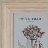Close-up of Hill Interiors Wooden Photo Frame 4x6 in white, showing the painted wood corner with visible grain and a floral insert print.