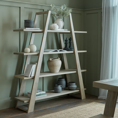 Hill Interiors Wooden A-Frame Ladder Shelving Unit in brown, styled with vases, books and ornaments against a sage green panelled wall.