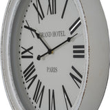Hill Interiors Round Glass-Fronted Wall Clock in white with wooden frame, black Roman numerals, and Grand Hotel Paris text, shown at an angle.