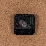 Back of a black quartz clock movement with visible gears and AA 1.5V battery compartment, part of the Hill Interiors Round Glass-Fronted Wall Clock.