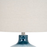 Close-up of Hill Interiors Glass Table Lamp showing the rippled blue moulded glass base and natural linen drum shade against a white background.