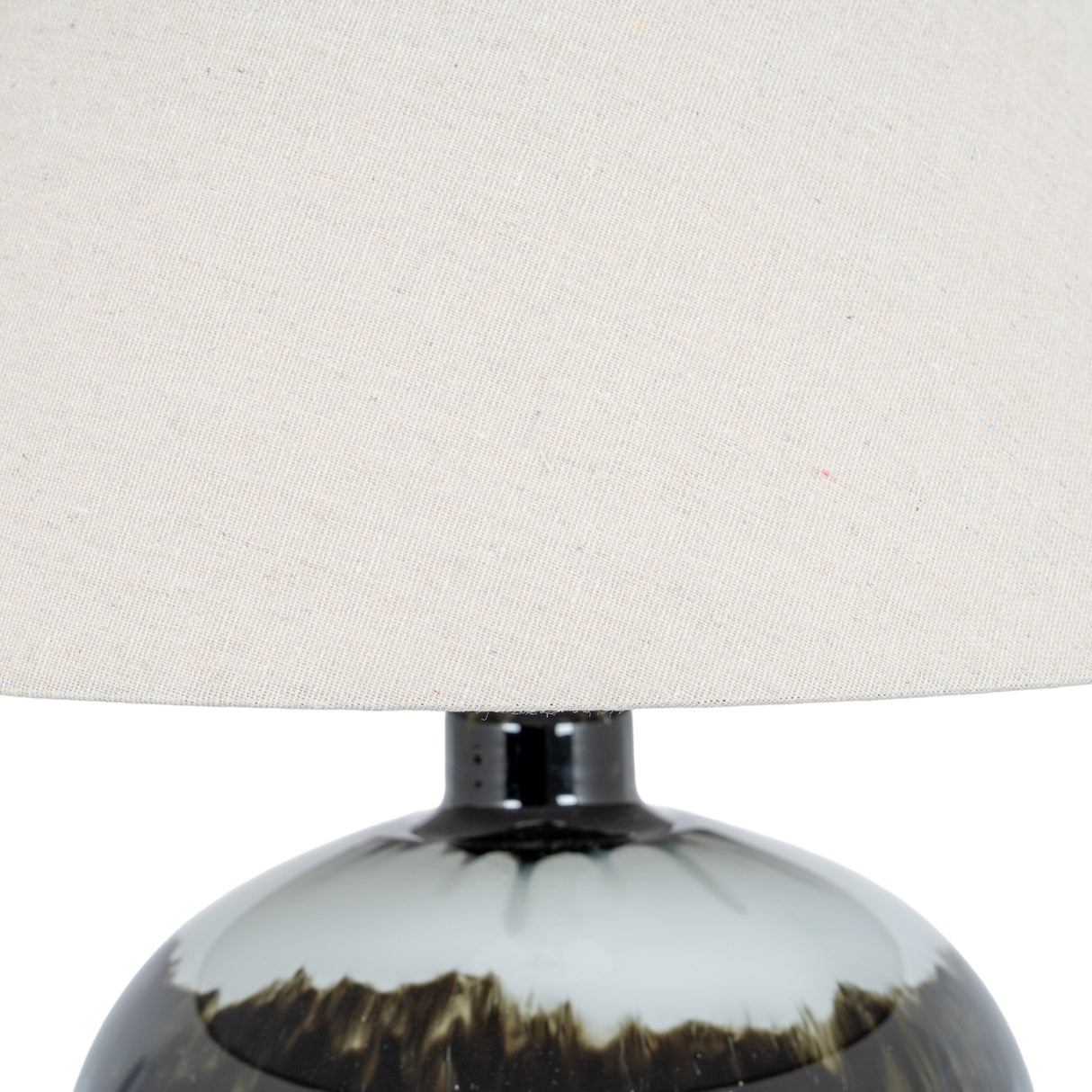 Close-up of the Hill Interiors Squat Glass Table Lamp showing the black glass base with subtle sheen and wide natural linen shade above.