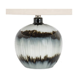 Hill Interiors squat table lamp with a rounded black glass base featuring white and brown drip glaze, topped with a natural linen shade.