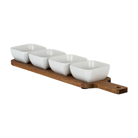 Hill Interiors acacia serving board in warm brown with four square white ceramic bowls arranged in a row, shown on a plain background.