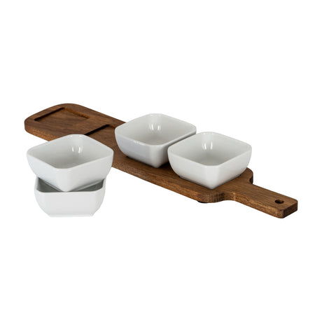 Hill Interiors acacia serving board with paddle handle and four square white ceramic bowls, three set in the board and one stacked, on a white background.