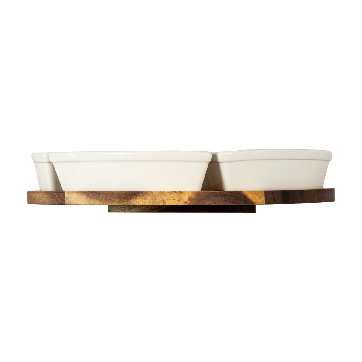Side view of Hill Interiors acacia lazy Susan with two white ceramic serving bowls on a round brown wooden rotating base, shown on a white background.
