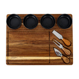 Hill Interiors acacia cheese board set with four black ceramic bowls and three wooden-handled cheese knives arranged on the brown wooden board.