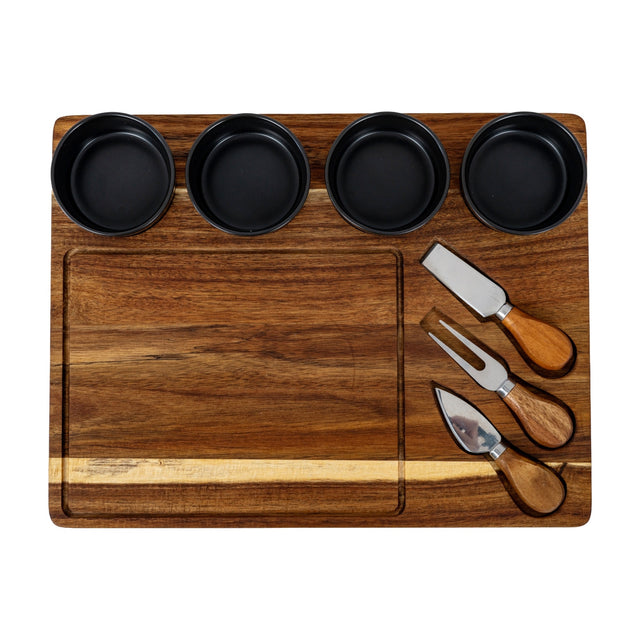 Hill Interiors acacia cheese board set with four black ceramic bowls and three wooden-handled cheese knives arranged on the brown wooden board.