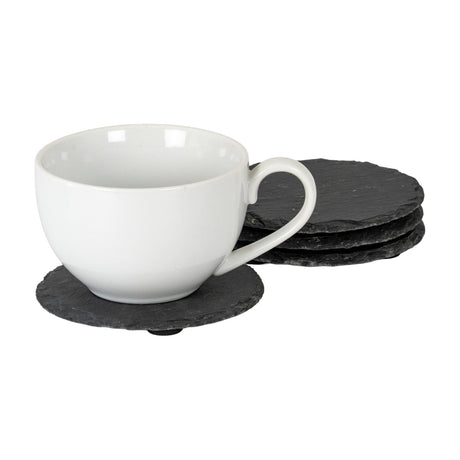 Hill Interiors Set of Four Round Slate Coasters in black, shown with a white ceramic teacup resting on one coaster and three stacked alongside.