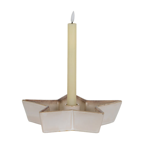 Hill Interiors large white ceramic five-pointed star candle holder with a central well holding a tall cream taper candle on a white background.