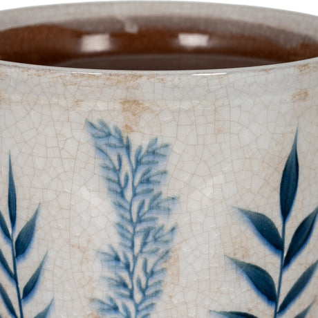 Close-up of Hill Interiors Small Ceramic Planter Pot showing crackle-glazed white surface with hand-painted blue leaf motifs and a warm brown glazed interior.