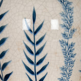 Close-up of Hill Interiors Blue Floral Amphora Jug Vase showing crackle-glazed white ceramic with hand-painted blue leafy stem motifs.