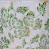 Close-up of the Hill Interiors Small Ceramic Clover Planter showing green floral motifs on a crackle-glazed white surface.