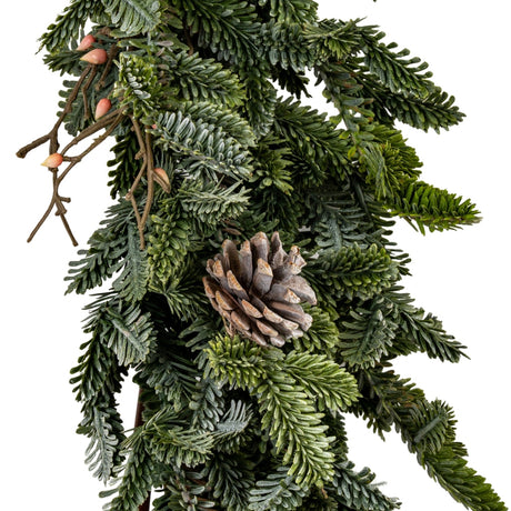 Close-up of Hill Interiors Woodland Pine Garland showing deep green moulded plastic pine sprigs, a small pinecone and slim twigs against a white background.