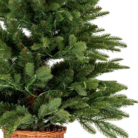 Close-up of Hill Interiors Pre-Lit LED Fir Tree showing dense green plastic branches with integrated warm LED string lights set in a woven rattan pot.