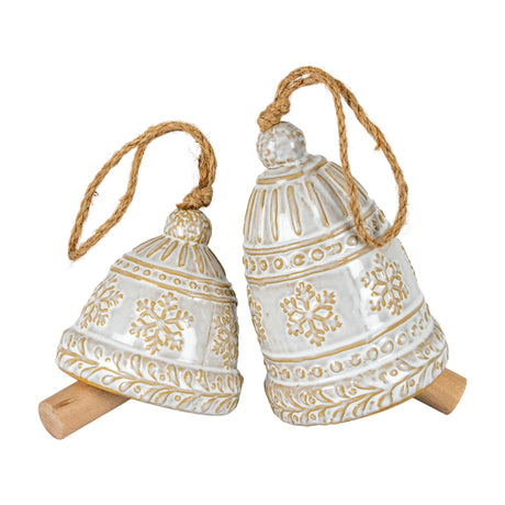 Hill Interiors ceramic bell ornaments in white with raised snowflake detail and jute hanging loops, resting on a plain white background.