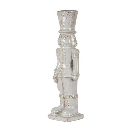 Hill Interiors Ceramic Nutcracker With Stocking in white, a tall glazed soldier figure with tall hat and moulded uniform detail, on a plain background.