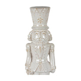 Hill Interiors white ceramic nutcracker figure with glazed finish, moulded soldier uniform, tall crown-trimmed hat and snowflake detail on a plain background.