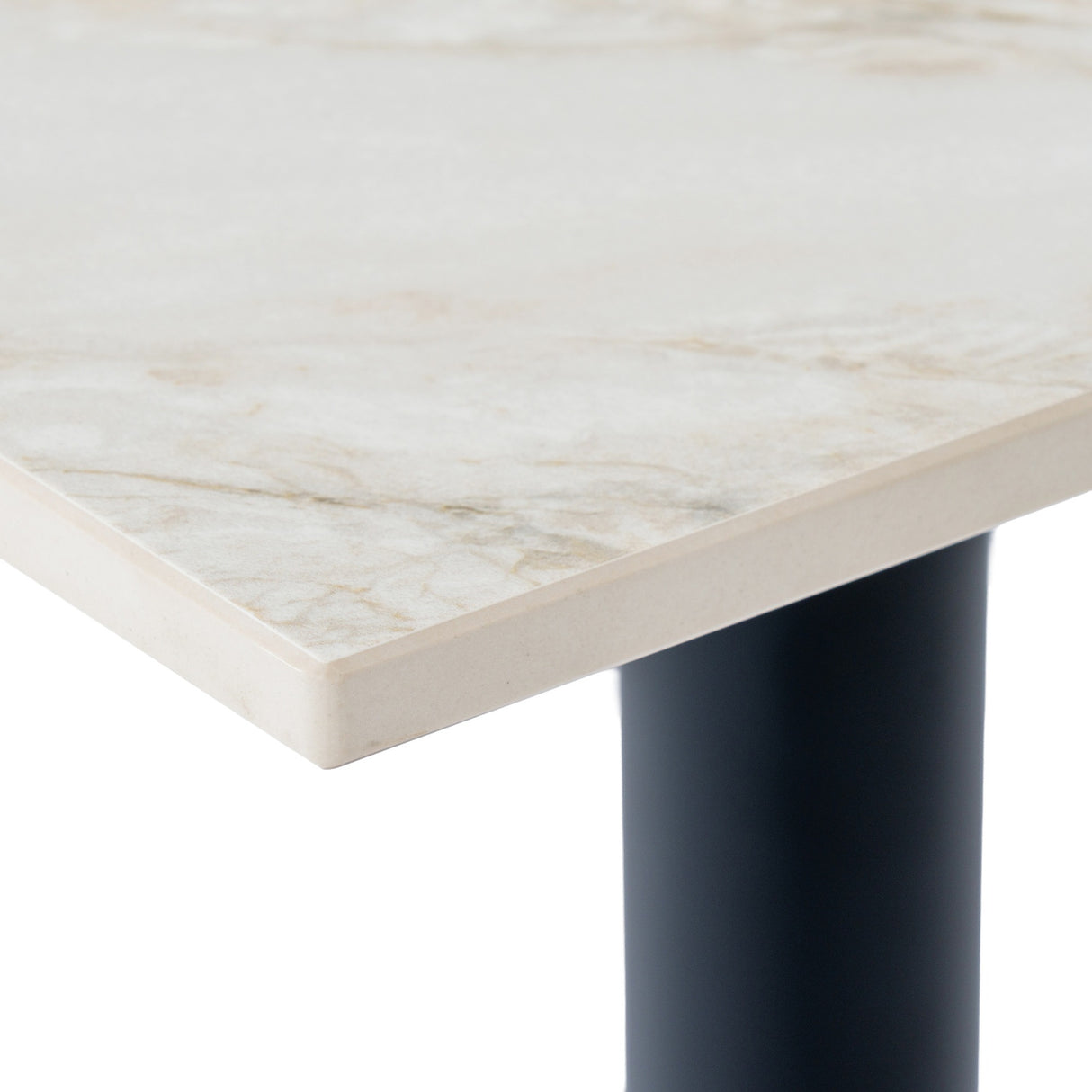 Close-up of the Hill Interiors Stanwyke dining table corner showing the beige stone-effect top with subtle veining and a matte black cylindrical metal leg.