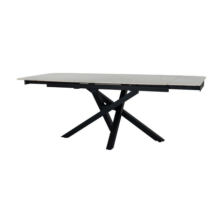 Hill Interiors Stanwyke extending dining table with a beige stone-look top and crossed matte black metal base, shown on a plain white background.